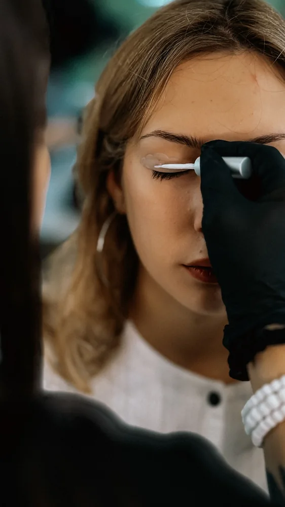 Esthéticienne réalisant un rehaussement de cils sur une cliente