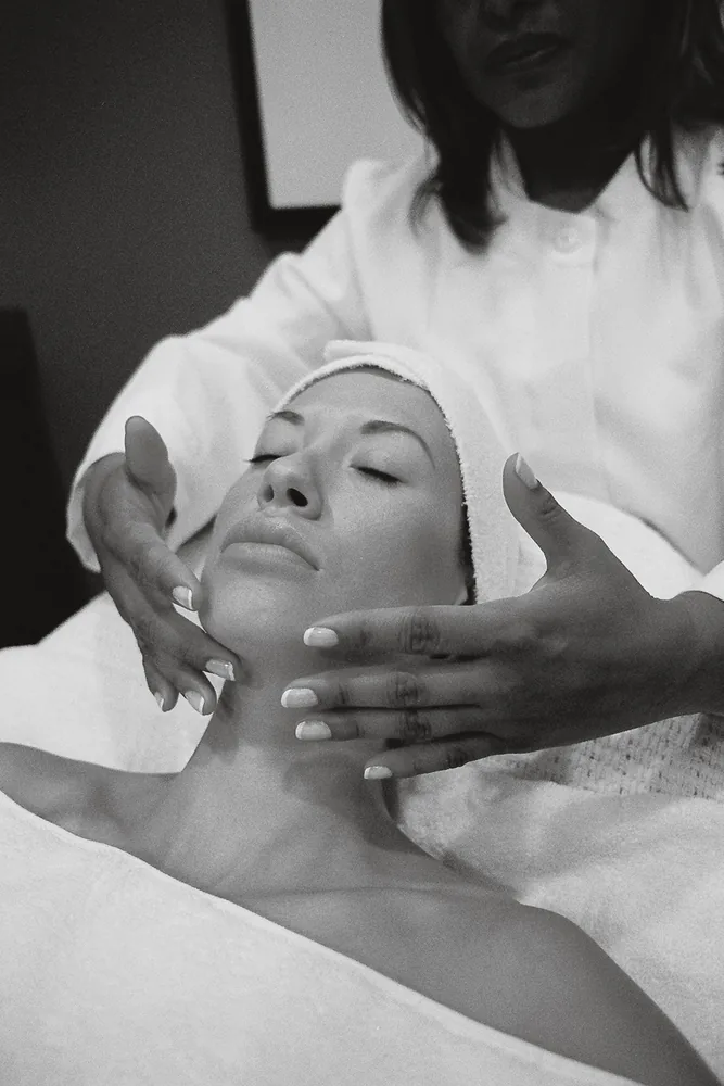 Esthéticienne réalisant un modelage hydratant du visage